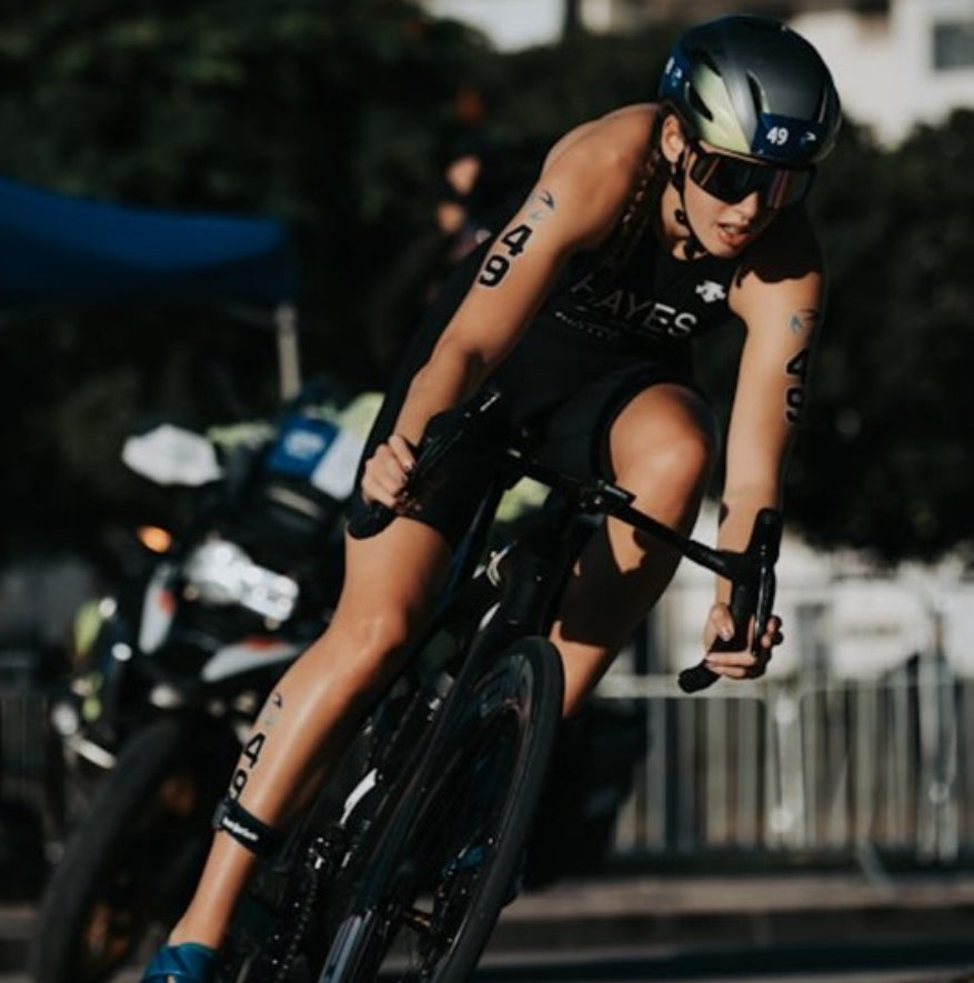 Issy Hayes riding a bicycle in a triathlon
